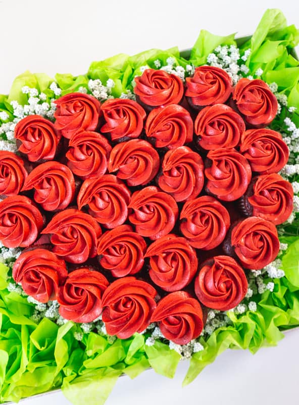 close up of mini cupcakes with red rosettes