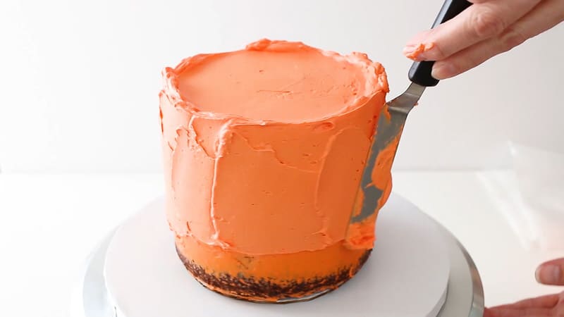 adding a second coat of buttercream to cake