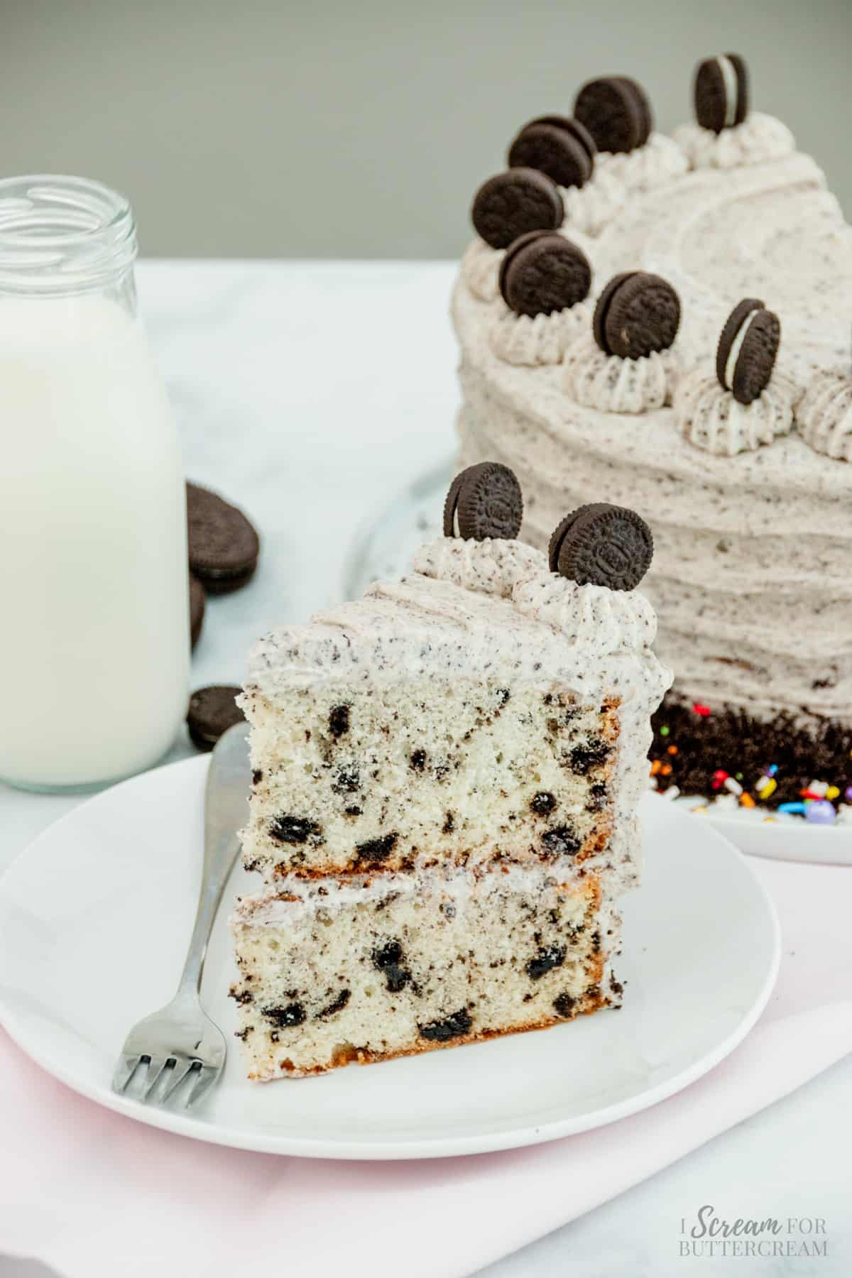 Large slice of layer cake with oreo frosting on a white plate.