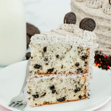 Oreo layer cake on a white plate with a fork.