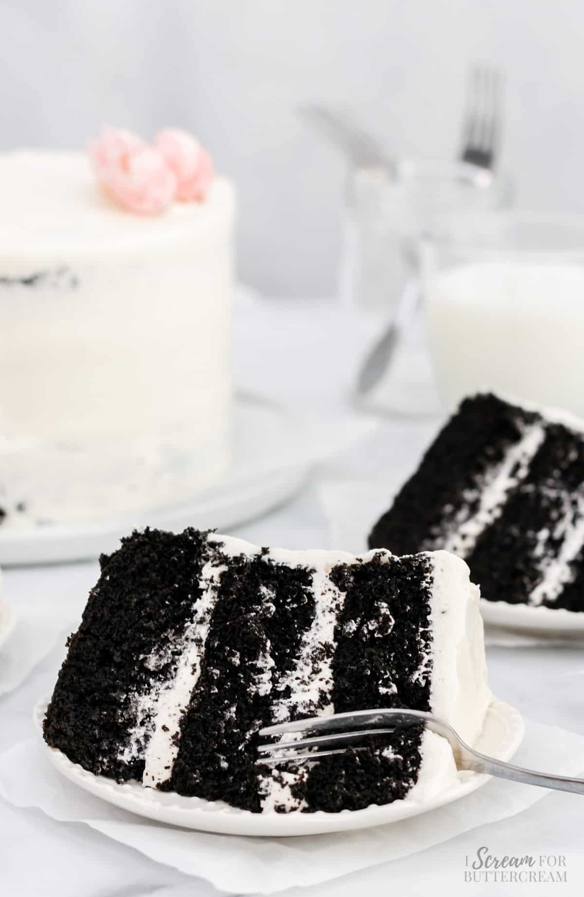 Black and white cake with fork on a white plate.