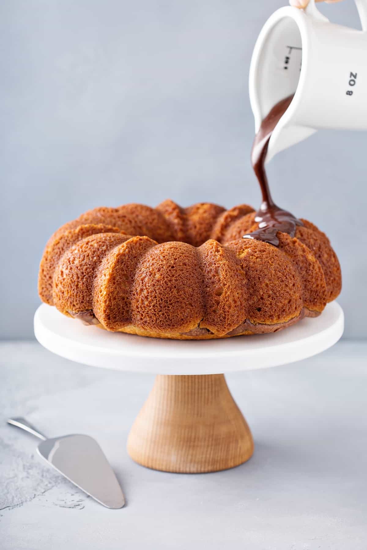 Pouring chocolate onto a bundt cake.