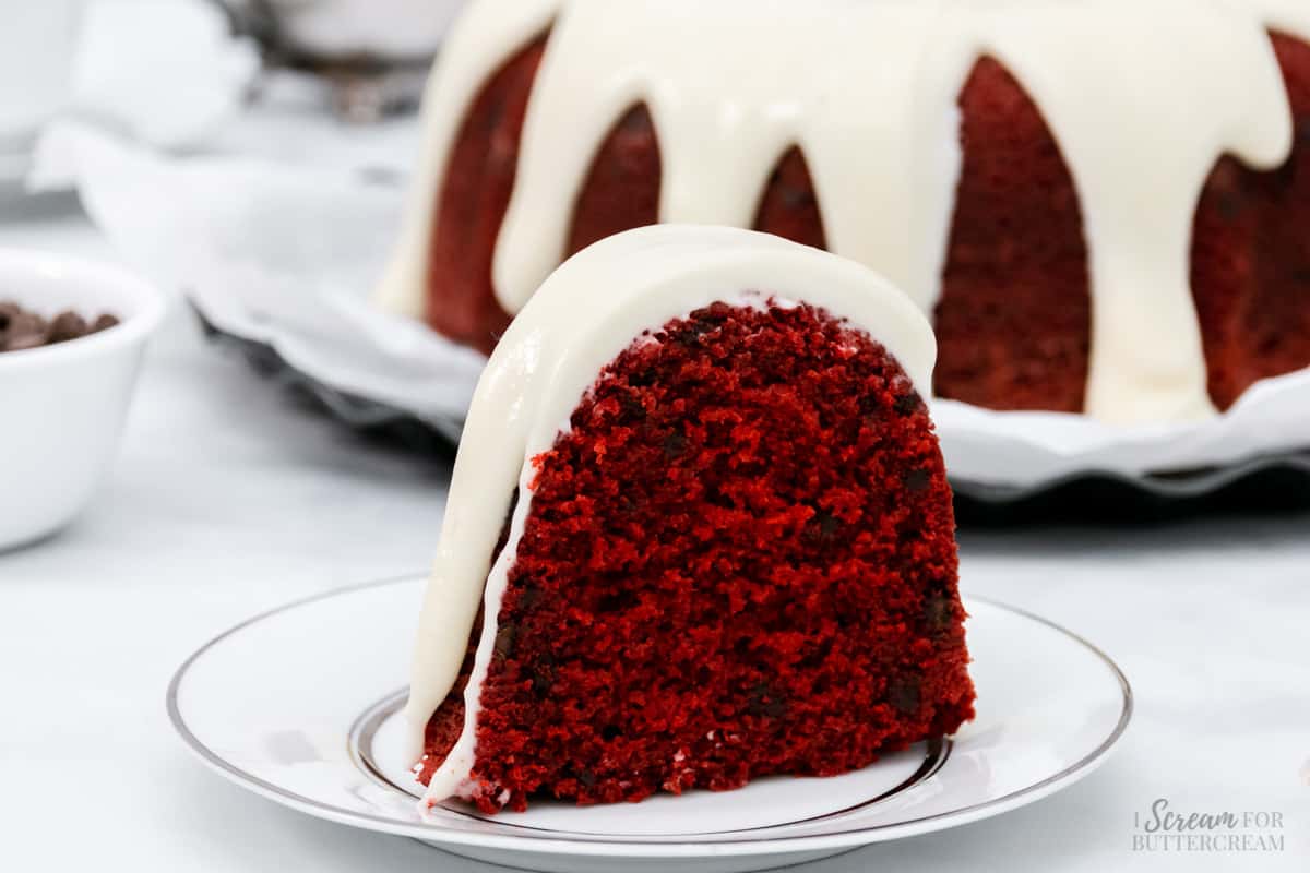 Close up of red velvet cake with glaze on a white cake.