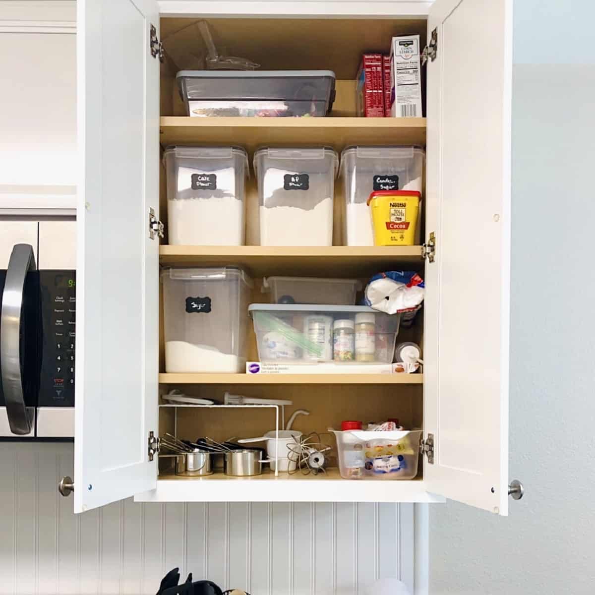 Cabinet with containers of baking ingredients.