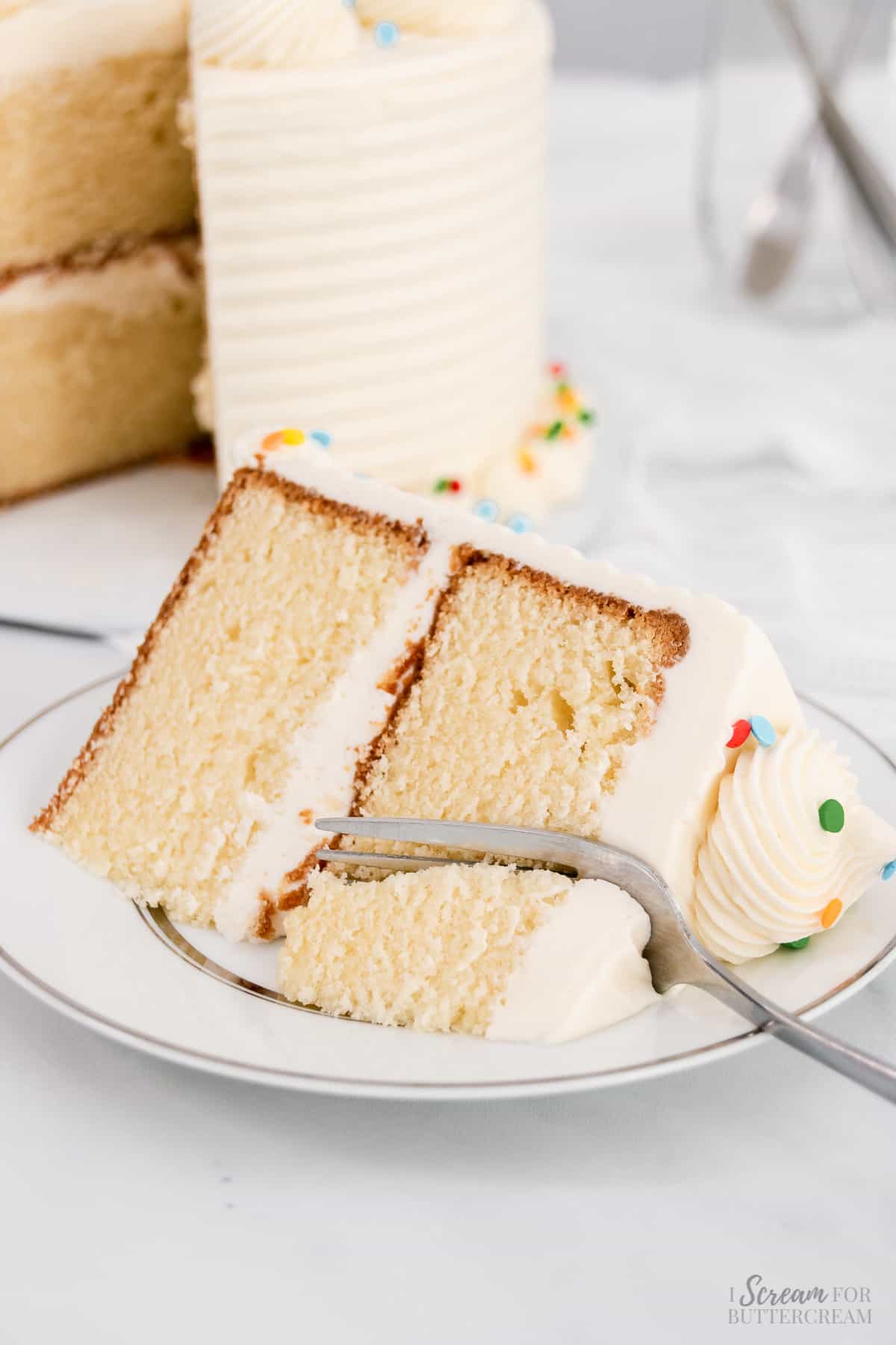Large slice of vanilla cake with fork.