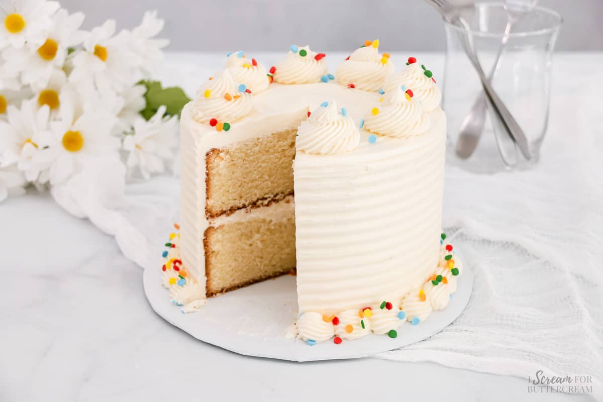 Vanilla mini cake decorated with slice out of it. 