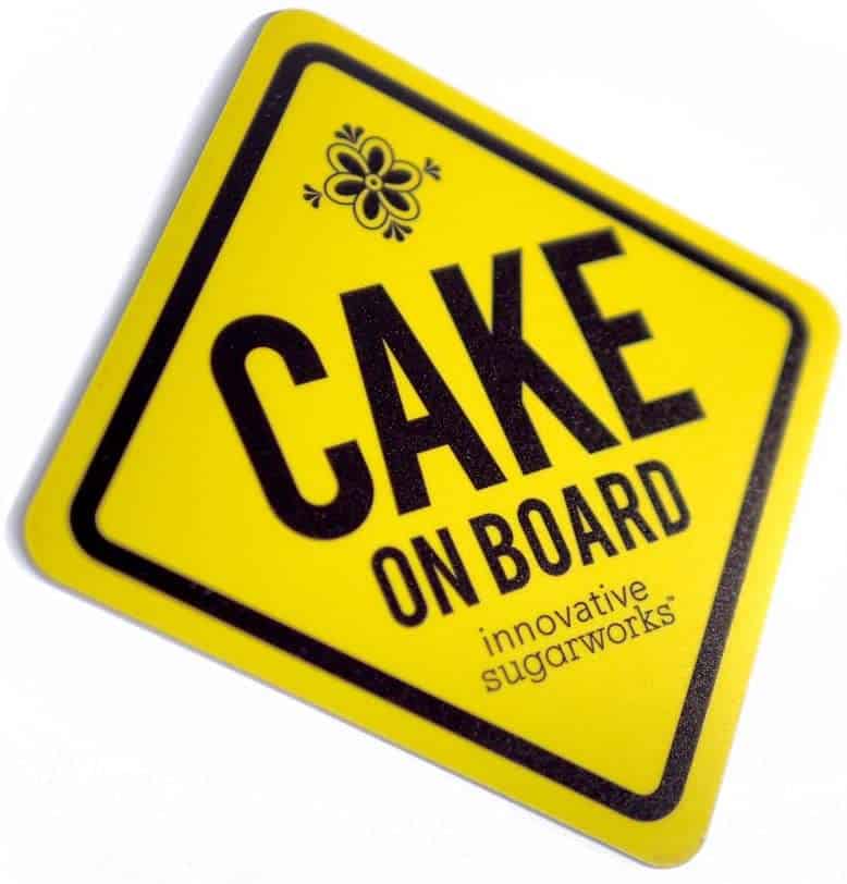 Yellow and black cake on board magnet for car.