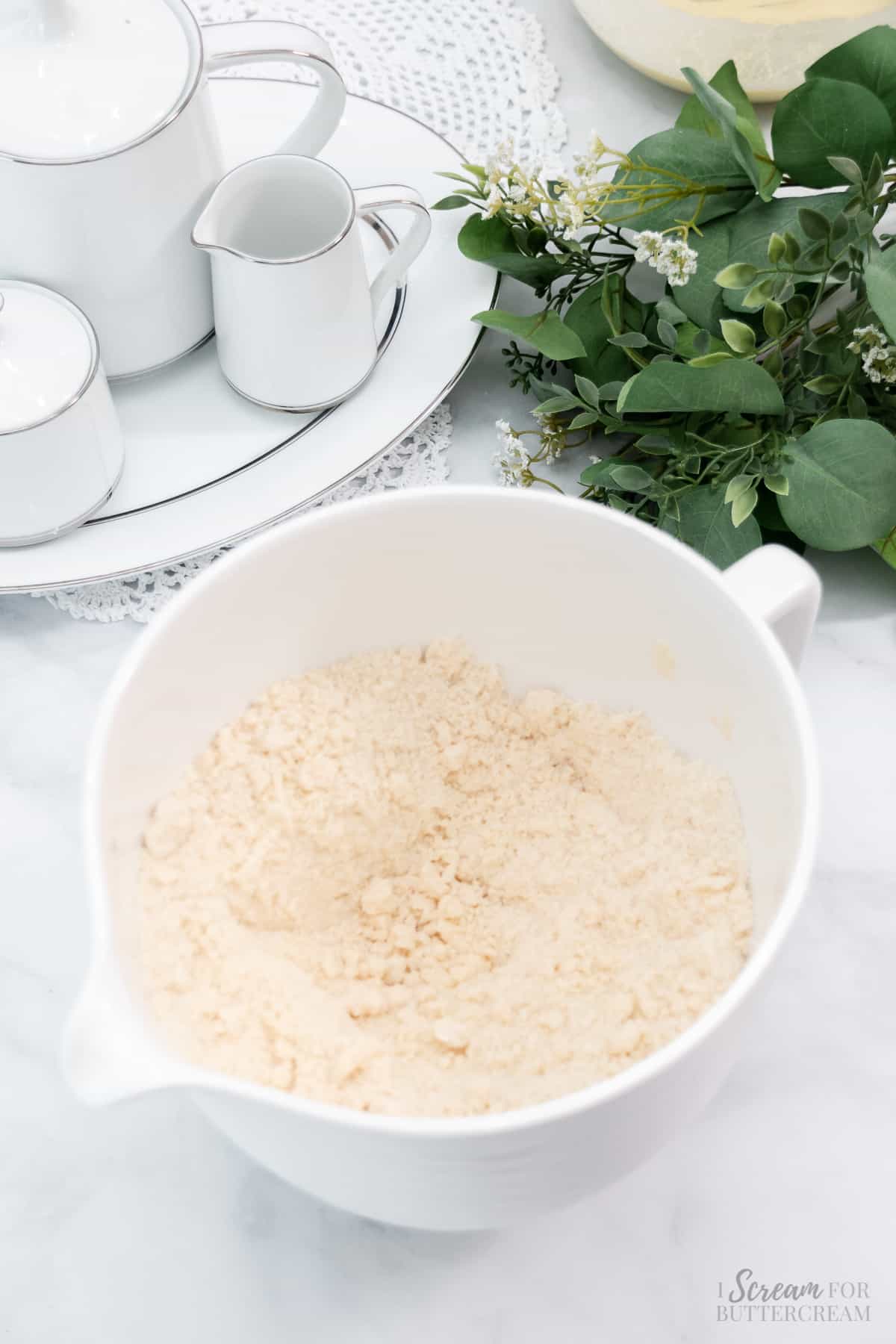Butter mixed with dry ingredients in a white mixing bowl.