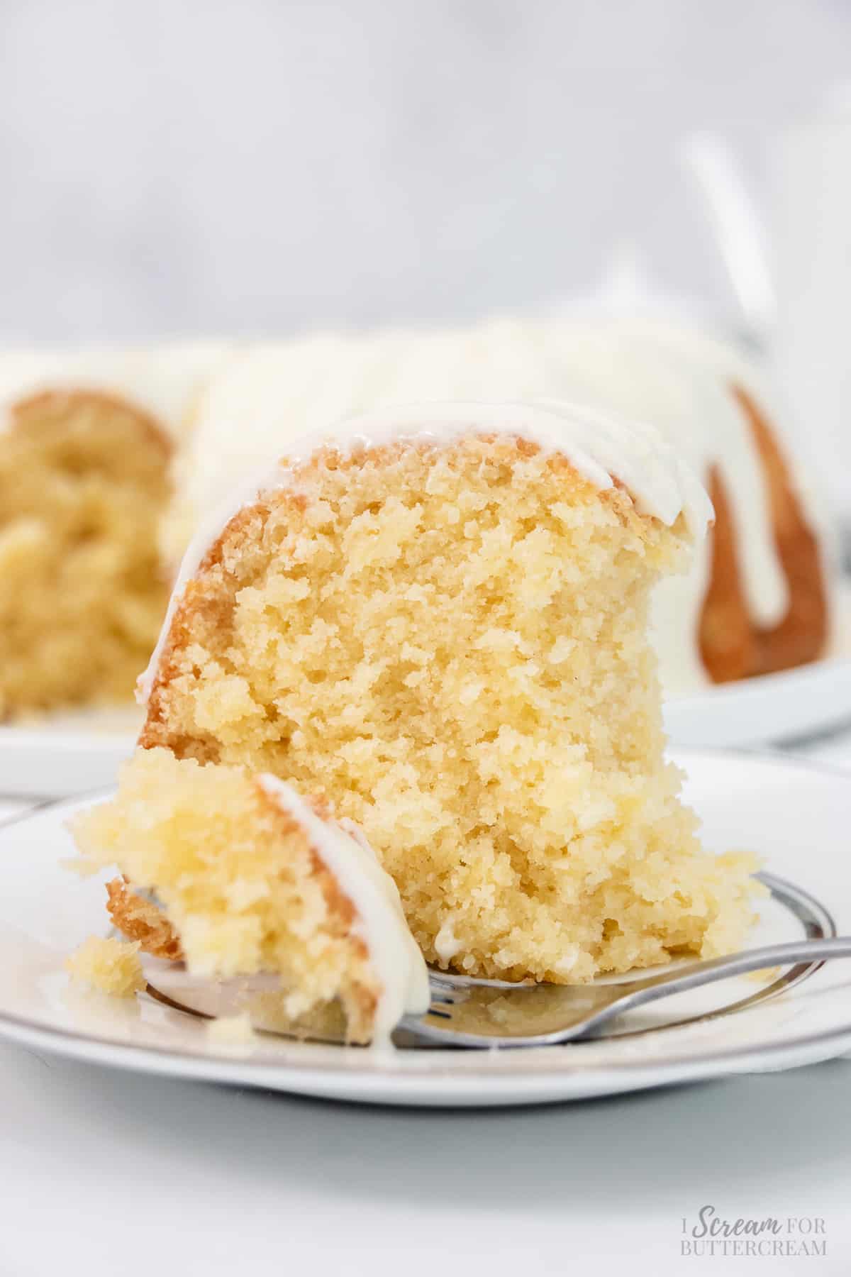 Large slice of bundt cake with bite cut out on a white plate.