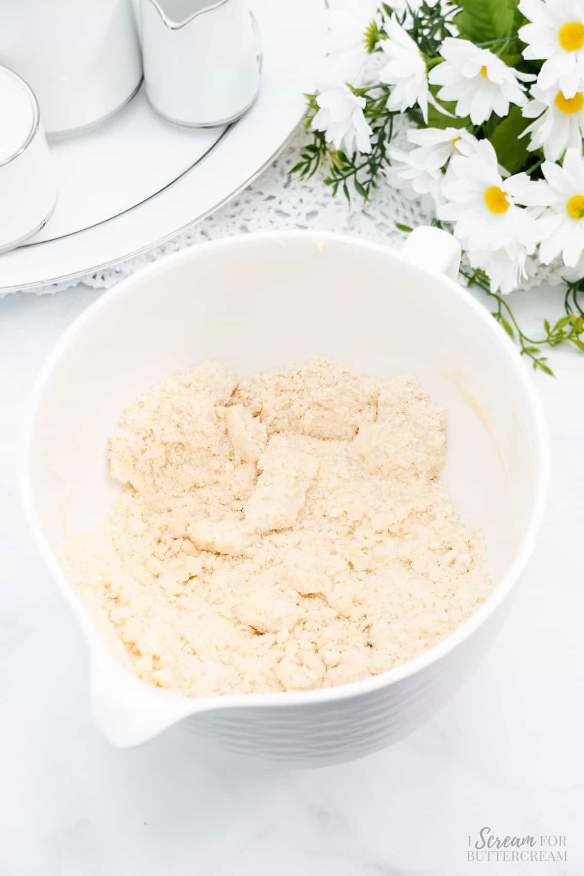 Butter mixed with dry ingredients in a white bowl.