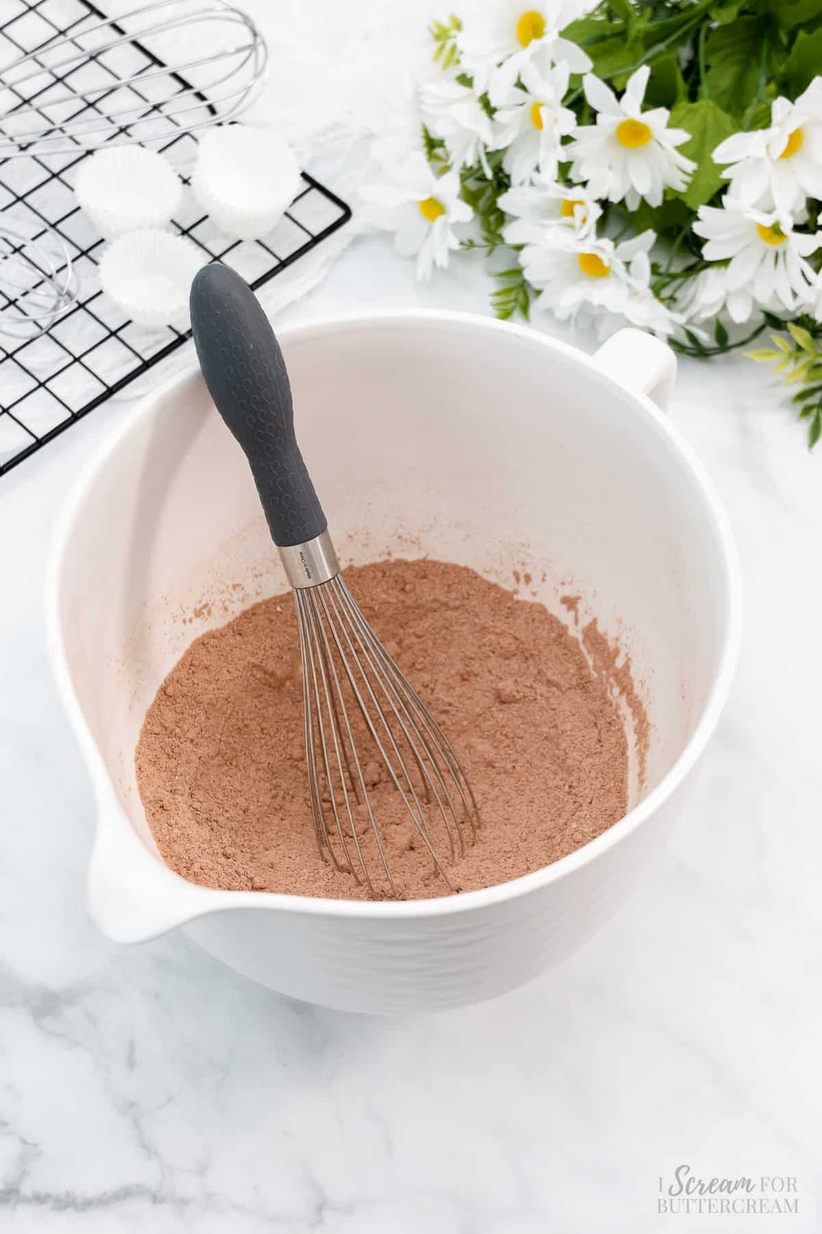 Dry ingredients in a white mixing bowl with a whisk.