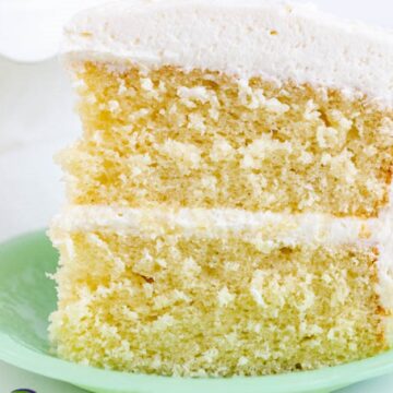 Close up of vanilla layer cake on a green plate.