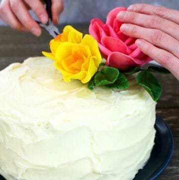 Attaching flowers to a cake.