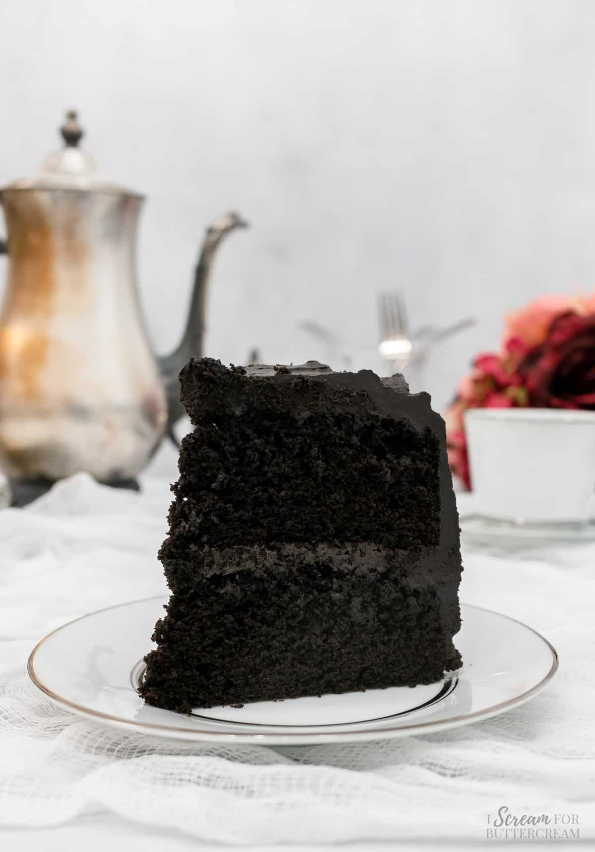 Large slice of black velvet cake on a white plate.