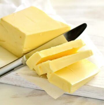 Butter on a wooden background with a knife.