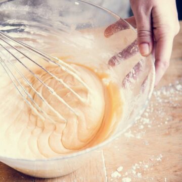 Mixing cake batter in a bowl with a whisk.