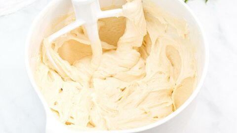 Vanilla cake batter in a large white mixing bowl with a mixer.