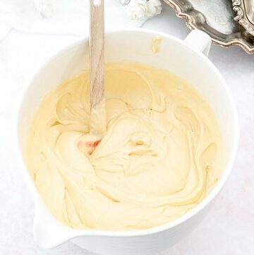 Vanilla cake batter in a bowl with a spatula.