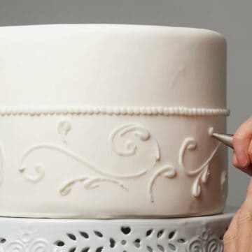 Piping icing onto a cake.