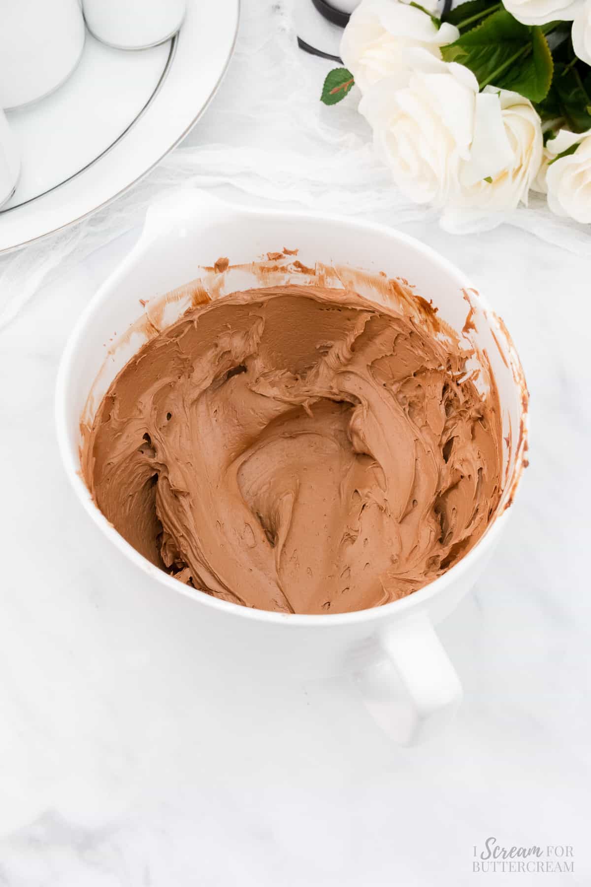 Chocolate buttercream in a white mixing bowl.