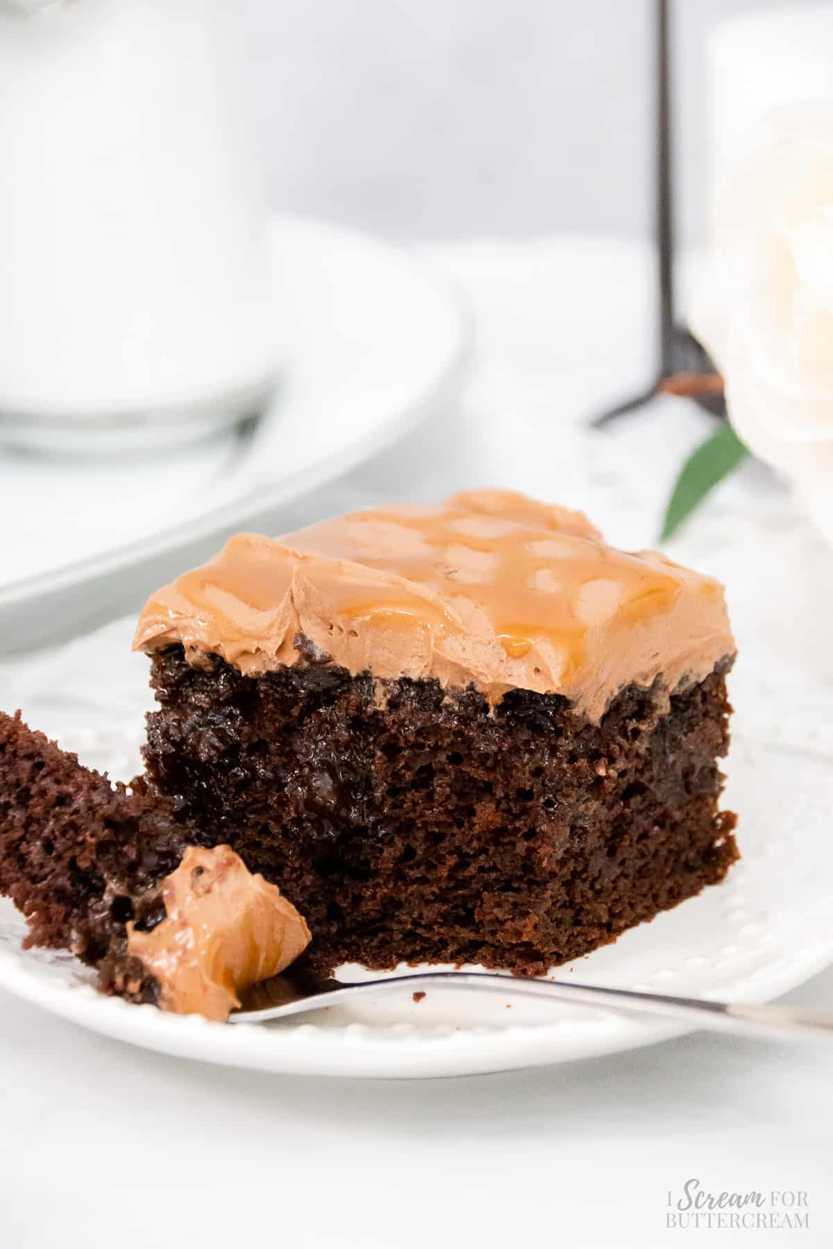 Chocolate cake with caramel buttercream on a plate with a fork.