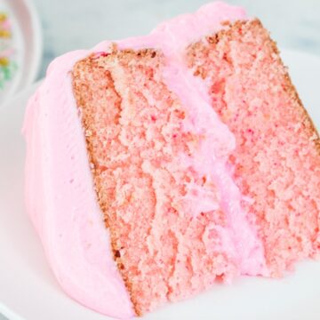 Close up of pink cake on a white plate.