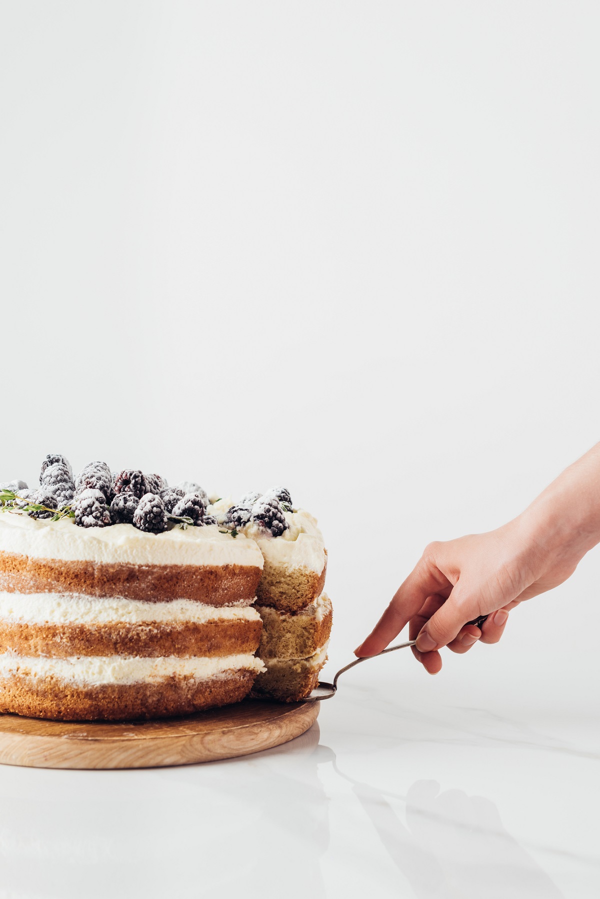 Layer cake with a cake server and hand.