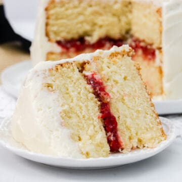 Large slice of vanilla layer cake with strawberry filling.