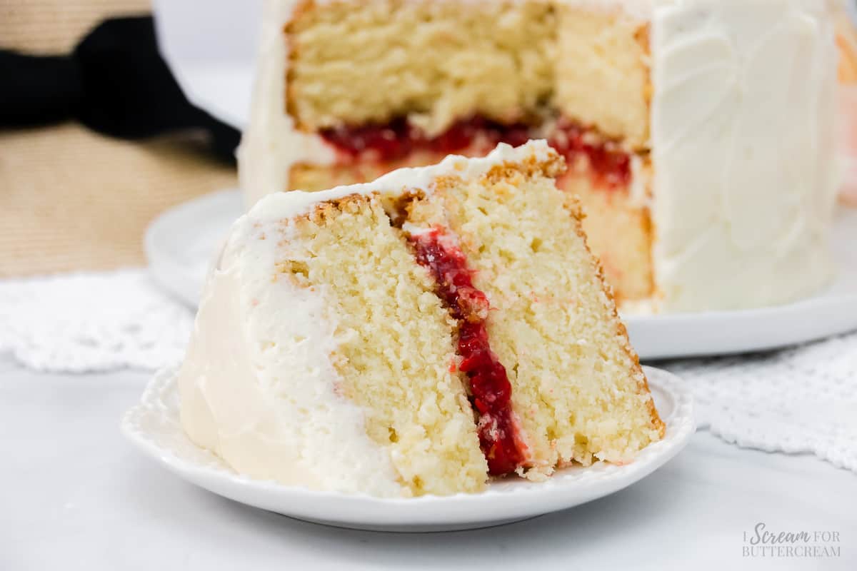 Large slice of vanilla layer cake with strawberry filling.