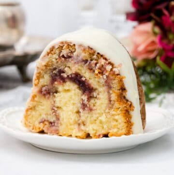 Featured image of raspberry swirl and white chocolate chip cake on a plate.