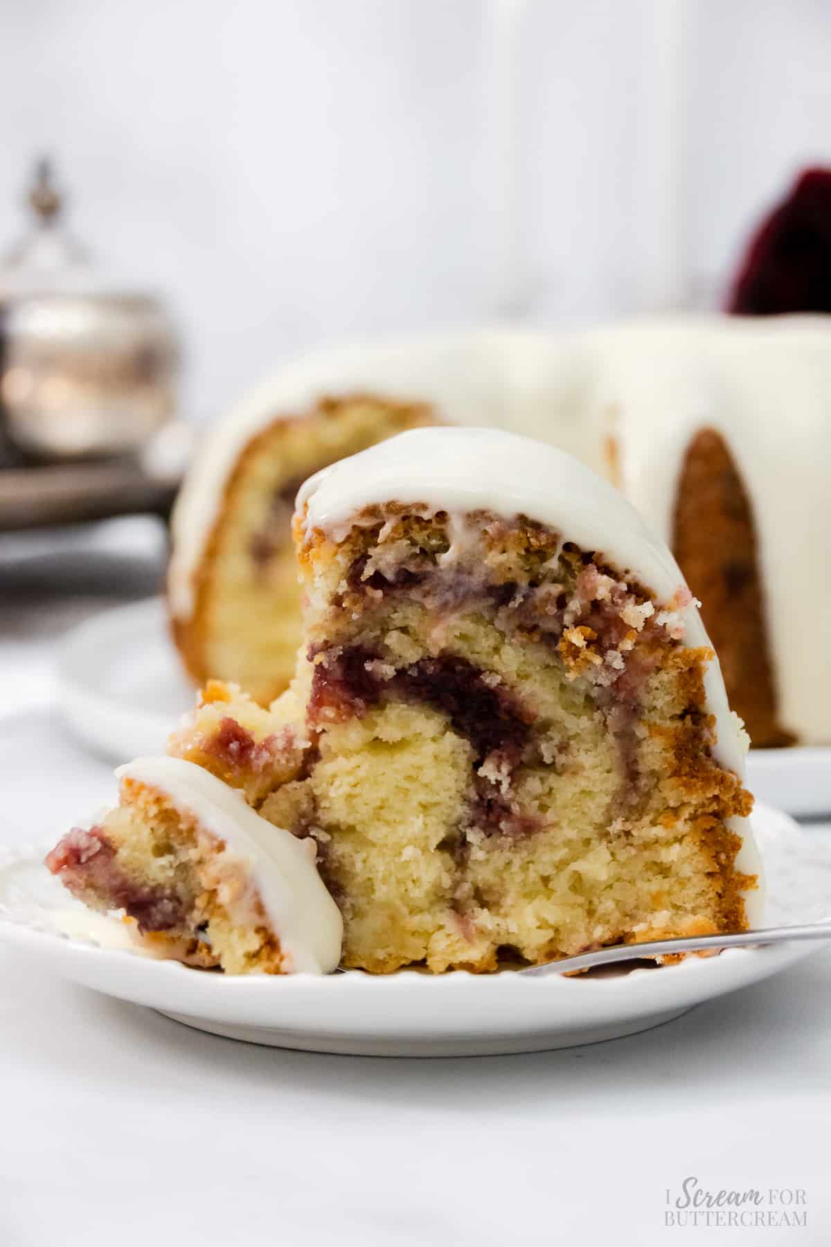 Slice of bundt cake with raspberry filling and fork.
