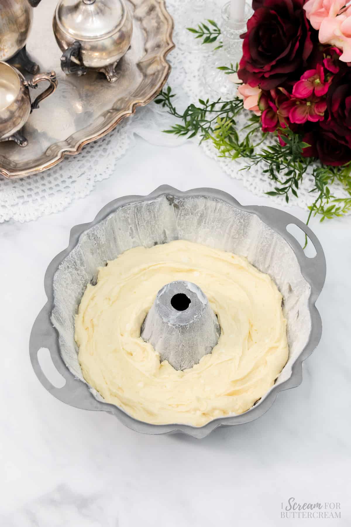 Adding a portion of the cake batter to the bundt pan.