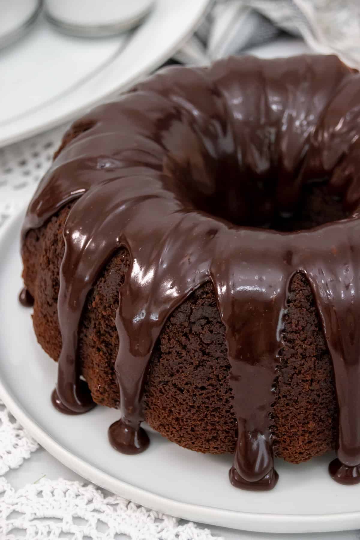 Close up side view of chocolate sour cream cake with chocolate glaze dripping down the side.
