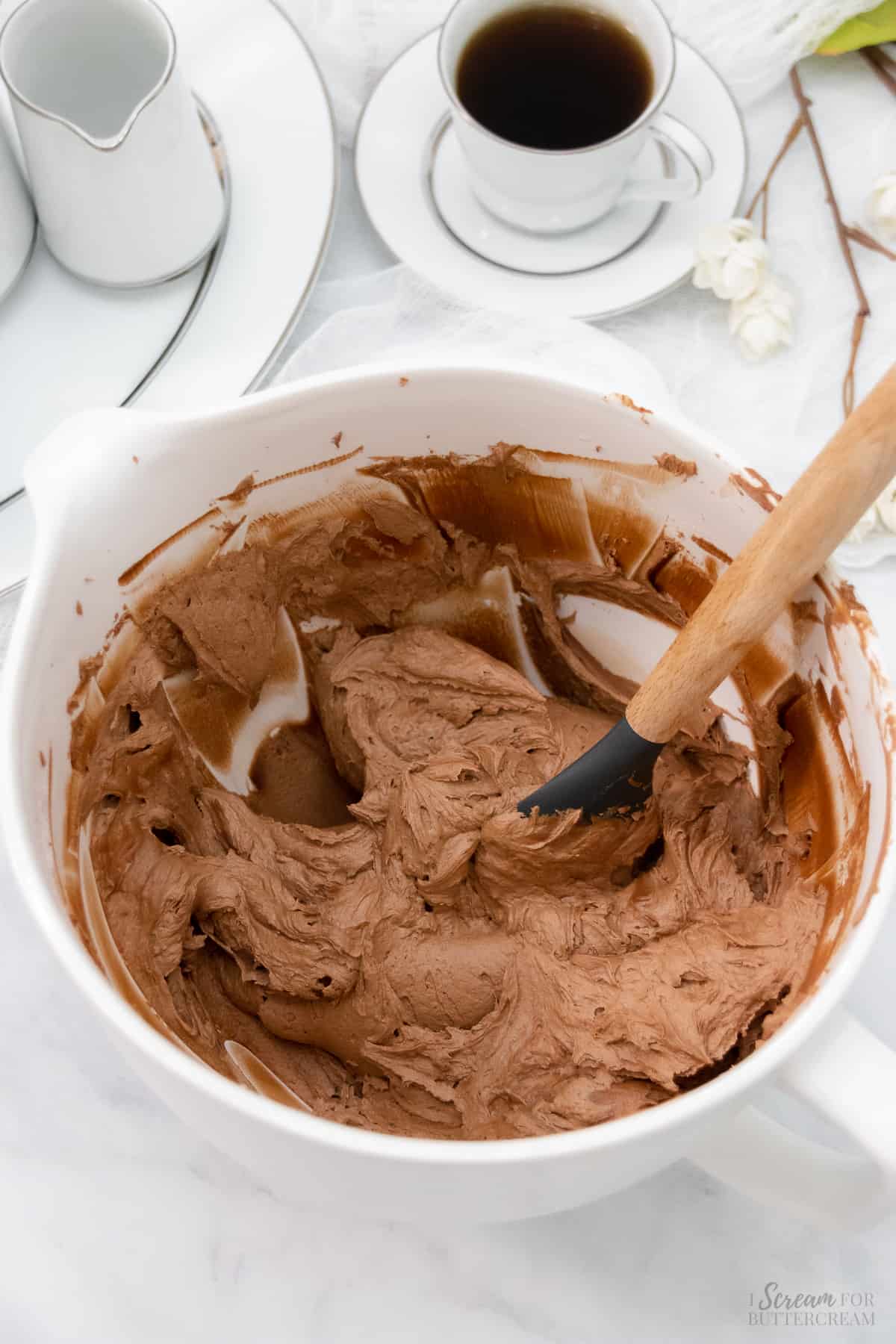 Chocolate nutella frosting made in a large white mixing bowl.