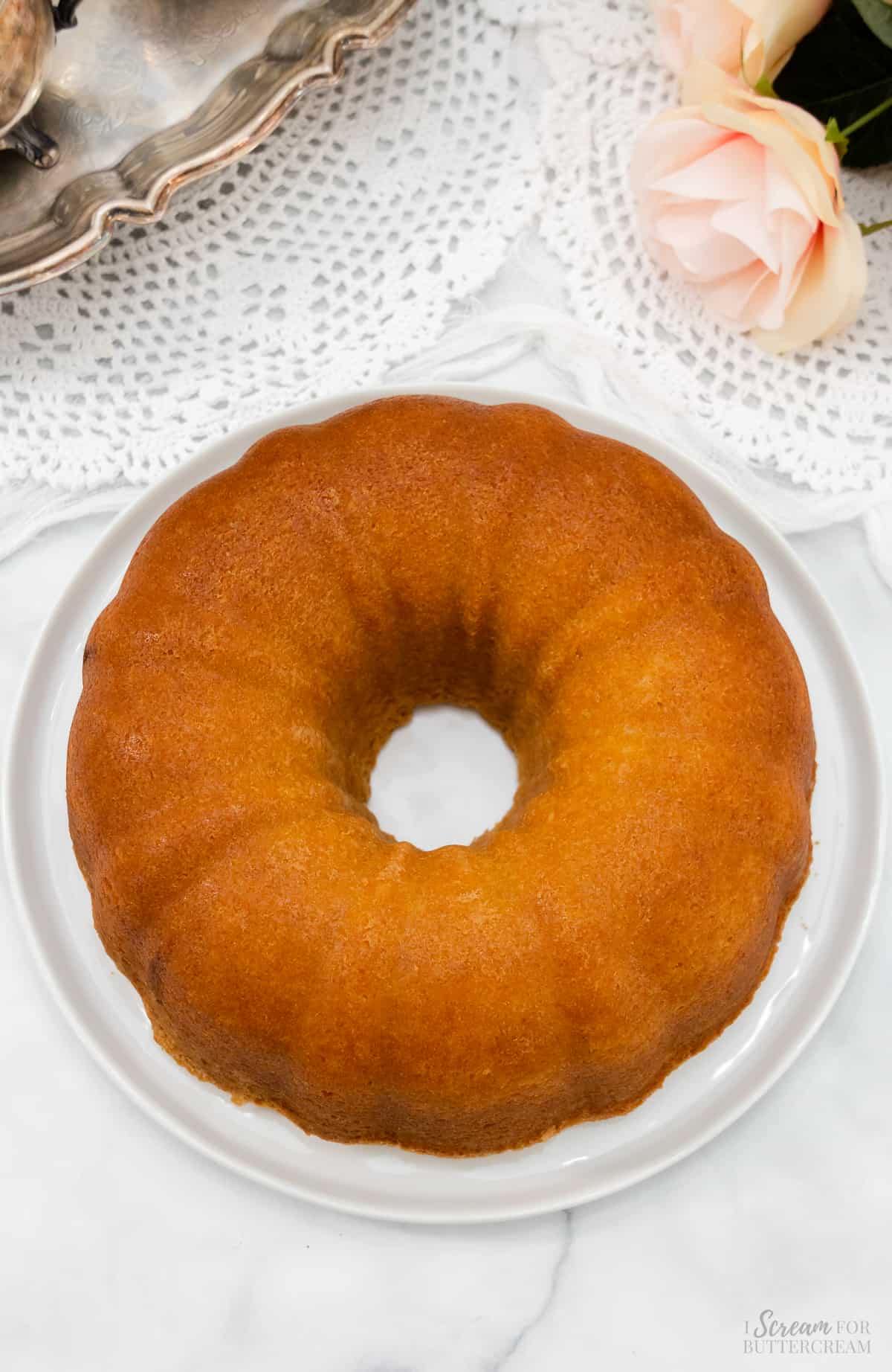Baked vanilla pound cake with buttermilk on a white platter.