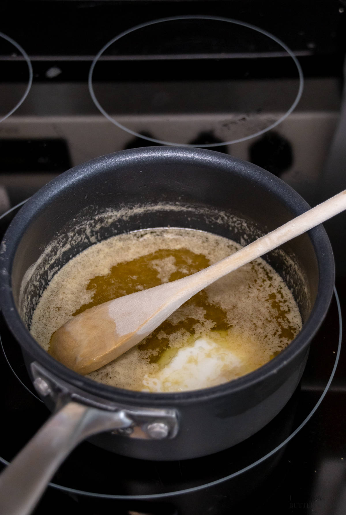 Melted butter and brown sugar in a small saucepan with a wooden spoon.