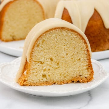 Wide image of slice of vanilla pound cake on a white plate.