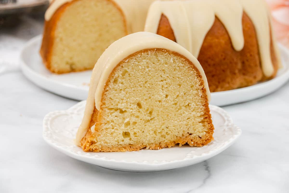 Wide image of slice of vanilla pound cake on a white plate.