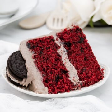 Large slice of deep red velvet cake with oreo on top.