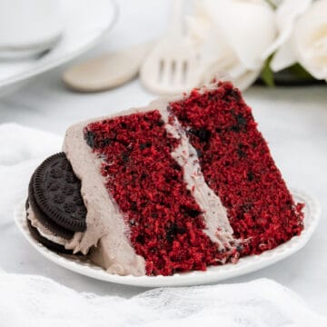 Slice of oreo red velvet cake on a white plate.