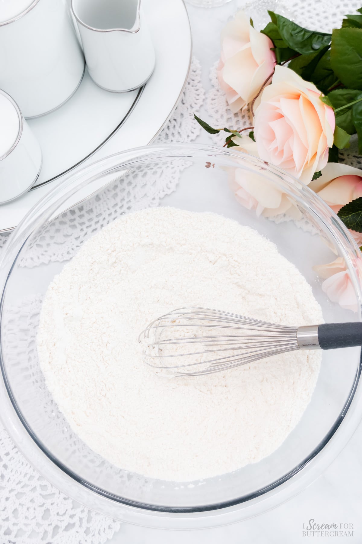 Large mixing bowl with dry ingredients in it with a whisk.