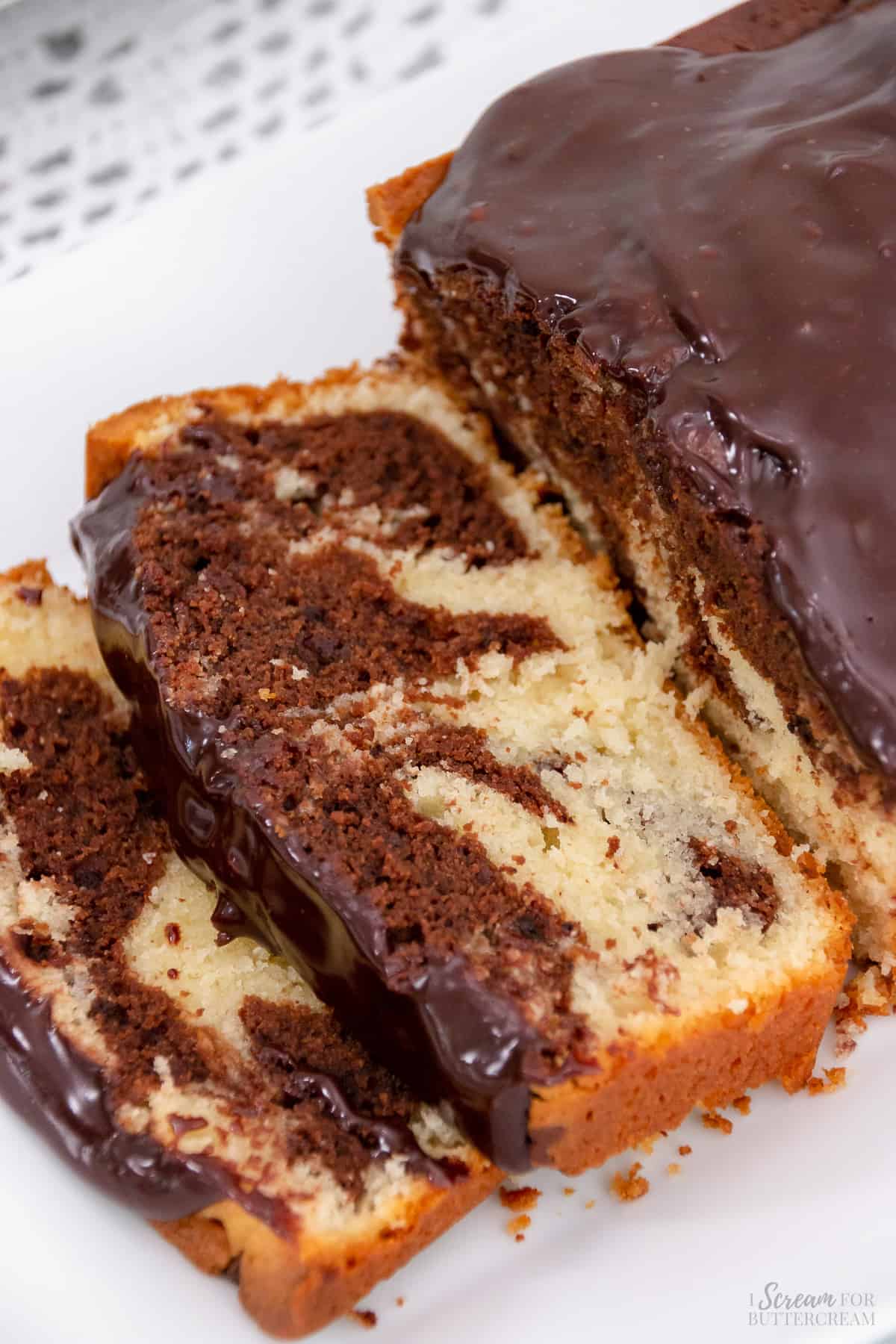 Top down view of marble snack cake sliced on a white platter.