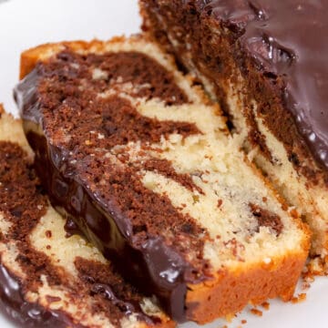 Close up view of chocolate and vanilla marble pound cake sliced on a plate.