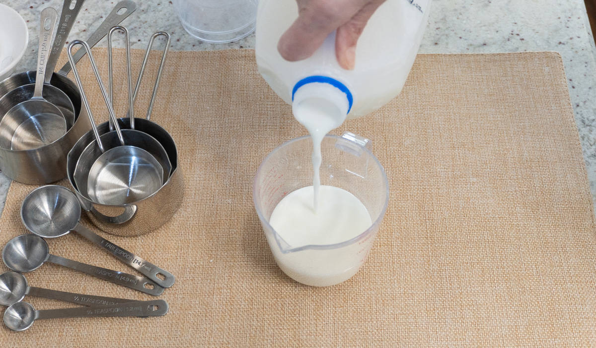 Pouring milk into a liquid measuring cup.