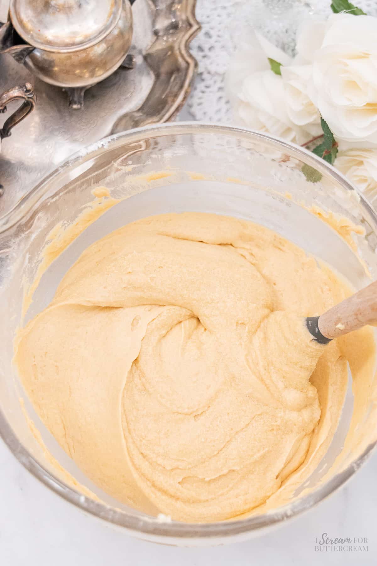 Mixed cake batter in a clear glass mixing bowl.