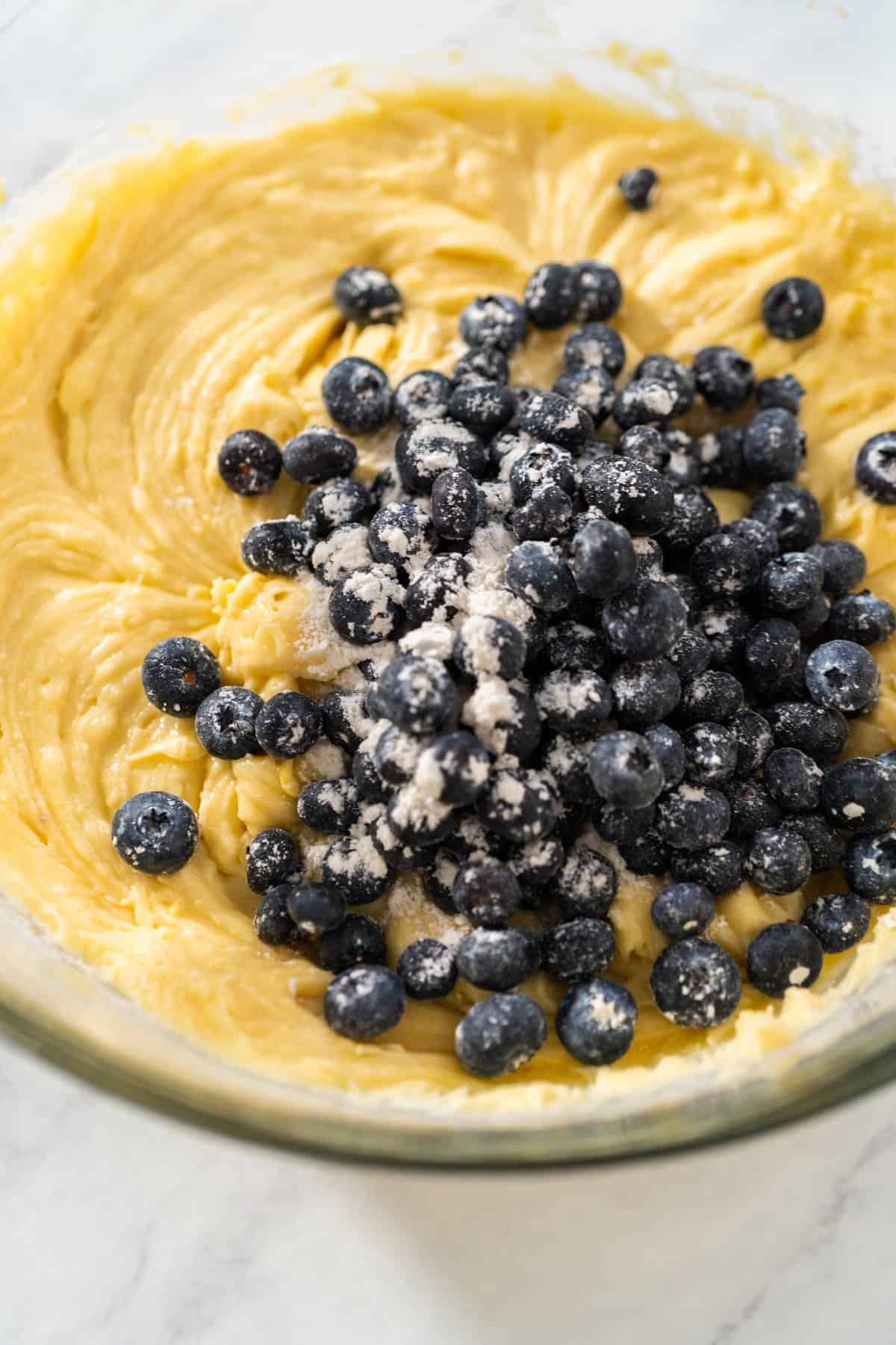 Cake batter in a bowl with blueberries.