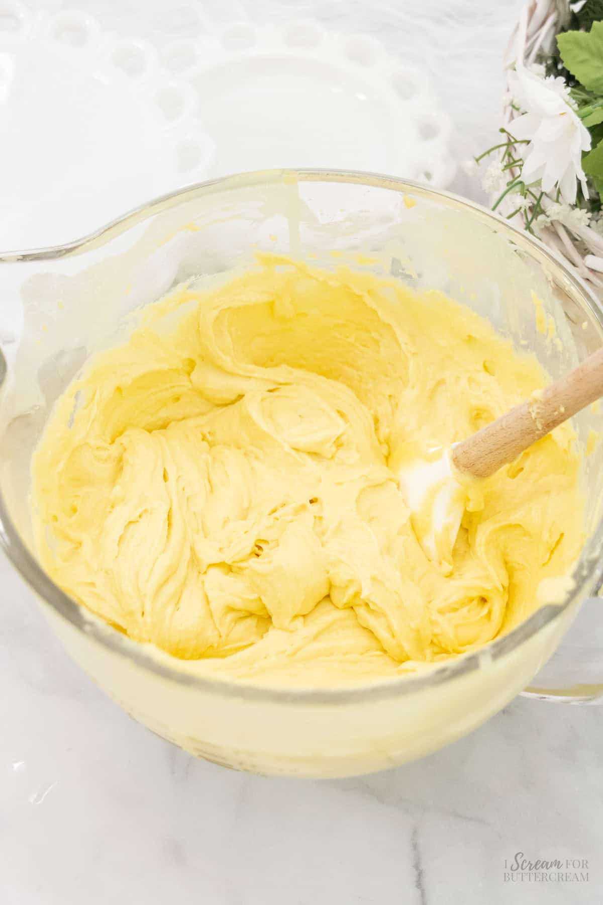 Lemon cake batter in a large glass mixing bowl with a spatula.