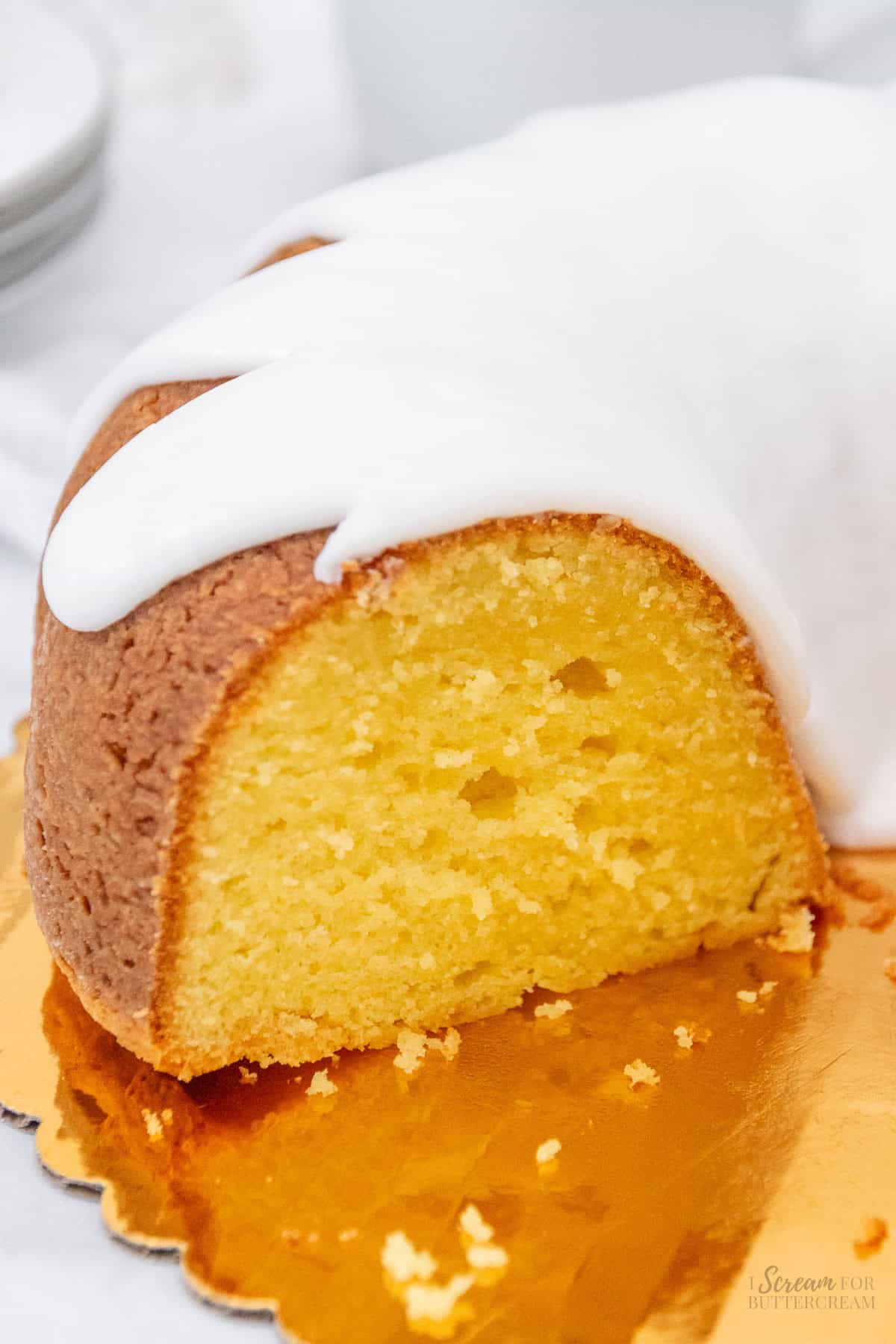 Lemon cream cheese bundt cake on a gold cake board.