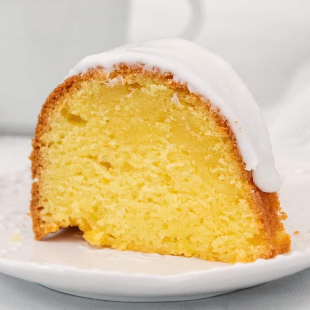 Large slice of lemon cake on a white plate.