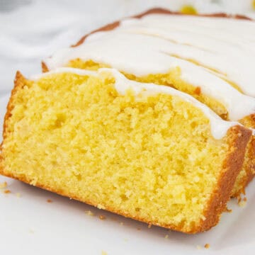 Close up of sliced lemon pound cake on a white platter.